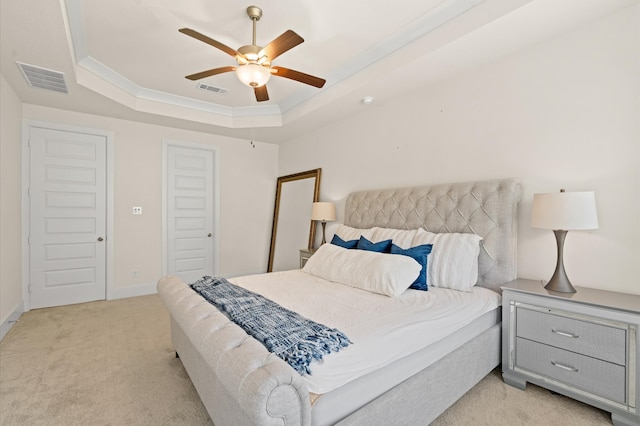 bedroom featuring light carpet, ceiling fan, and a raised ceiling