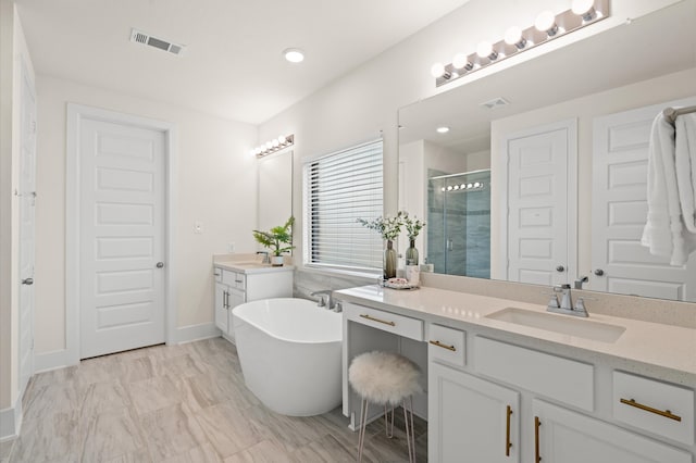 bathroom featuring shower with separate bathtub and vanity