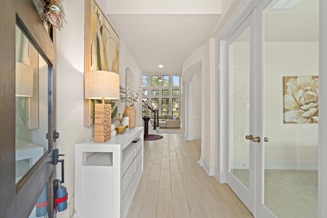 hall featuring light wood-type flooring and french doors