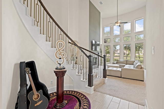 entrance foyer with carpet, a high ceiling, and ceiling fan