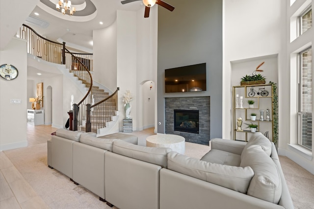 living room featuring ceiling fan with notable chandelier and a high ceiling