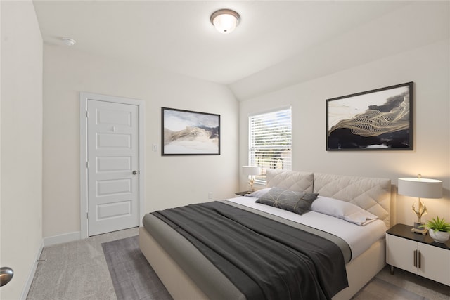 bedroom with carpet floors and vaulted ceiling