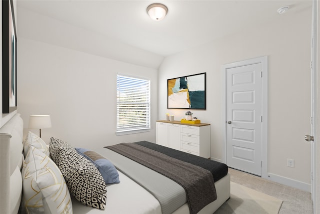 carpeted bedroom with lofted ceiling