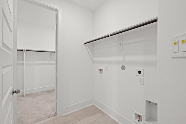 clothes washing area featuring light hardwood / wood-style flooring, hookup for an electric dryer, hookup for a washing machine, and gas dryer hookup