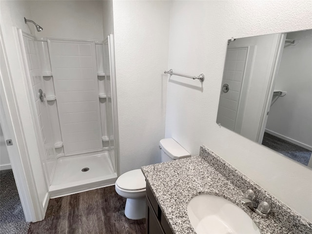 bathroom with walk in shower, vanity, toilet, and hardwood / wood-style flooring