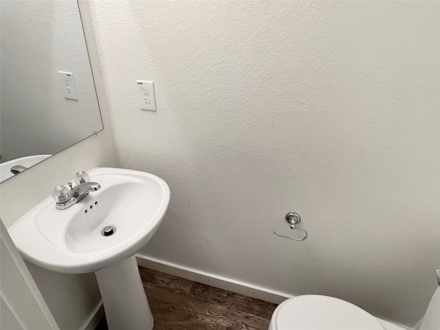 bathroom with hardwood / wood-style flooring and toilet