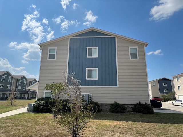 view of side of property with central AC and a yard