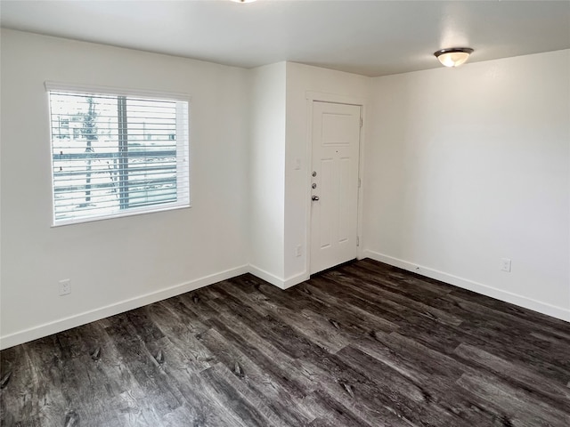 empty room with dark hardwood / wood-style flooring