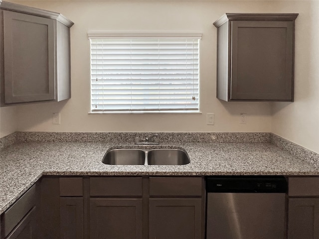 kitchen with light stone counters, dishwasher, plenty of natural light, and sink