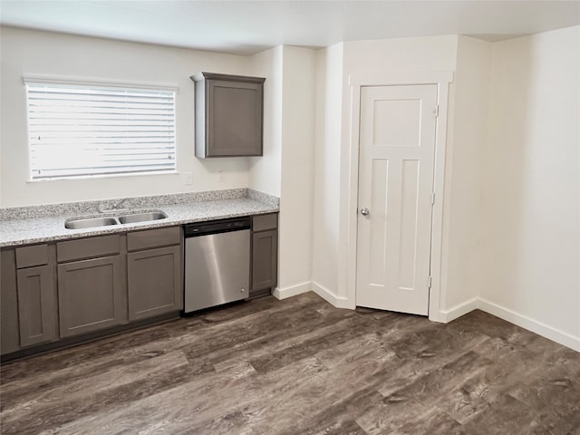 kitchen featuring light stone countertops, dark hardwood / wood-style floors, sink, and stainless steel dishwasher