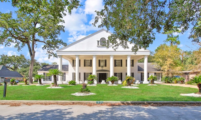 neoclassical home featuring a front lawn