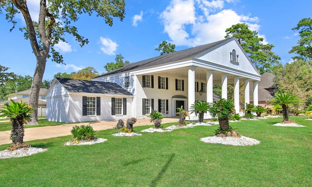 greek revival house featuring a front yard and covered porch