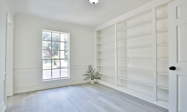 unfurnished room featuring ornamental molding, a textured ceiling, and hardwood / wood-style floors