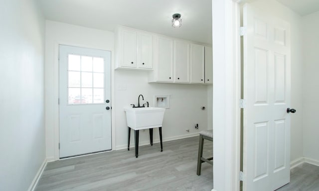 laundry room featuring cabinets, light hardwood / wood-style flooring, hookup for a washing machine, and gas dryer hookup