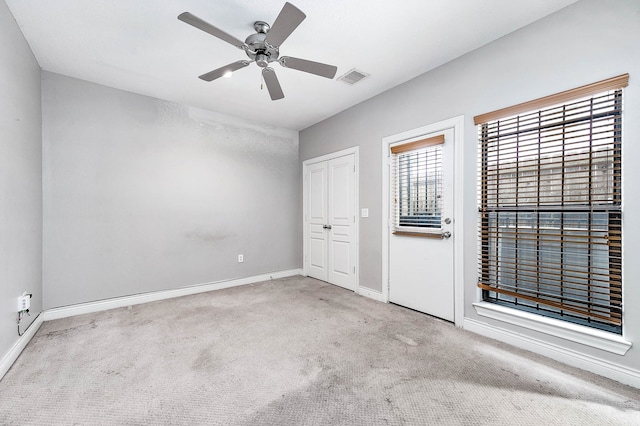 unfurnished bedroom with light carpet, ceiling fan, and a closet