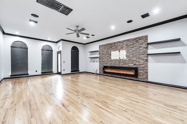 unfurnished living room featuring crown molding, a fireplace, ceiling fan, and light hardwood / wood-style flooring