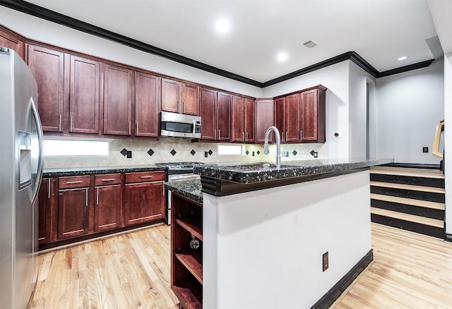 kitchen with light hardwood / wood-style floors, tasteful backsplash, stainless steel appliances, ornamental molding, and dark stone countertops