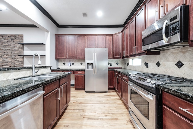 kitchen featuring light hardwood / wood-style floors, tasteful backsplash, sink, stainless steel appliances, and dark stone countertops