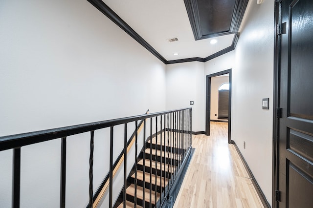 corridor featuring light wood-type flooring and ornamental molding