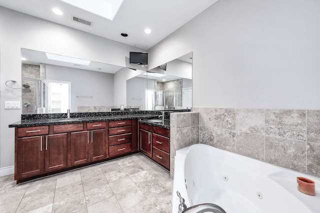 bathroom with vanity, separate shower and tub, and a skylight