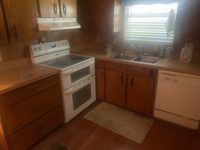 kitchen featuring range hood, white appliances, dark hardwood / wood-style flooring, and sink