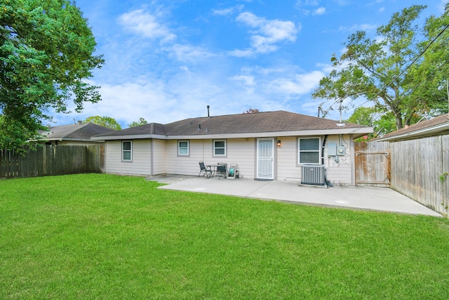 rear view of property featuring central AC unit, a lawn, and a patio