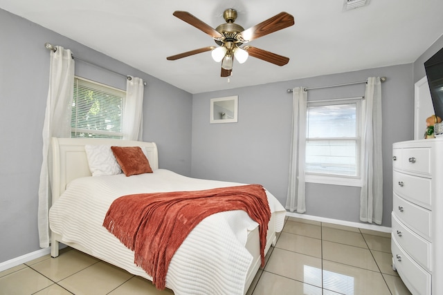 bedroom featuring light tile patterned flooring, ceiling fan, and multiple windows