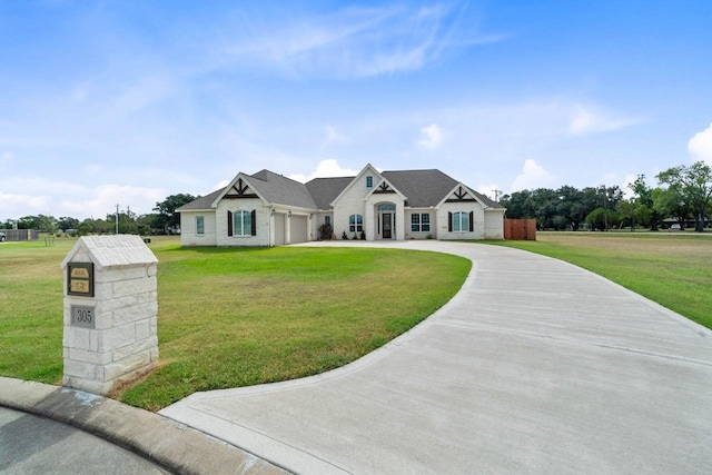 view of front facade featuring a front lawn, curved driveway, and a garage
