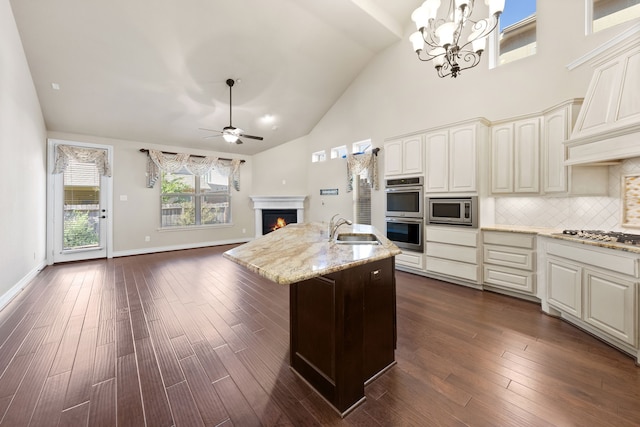 kitchen with ceiling fan with notable chandelier, stainless steel appliances, decorative light fixtures, dark hardwood / wood-style floors, and sink