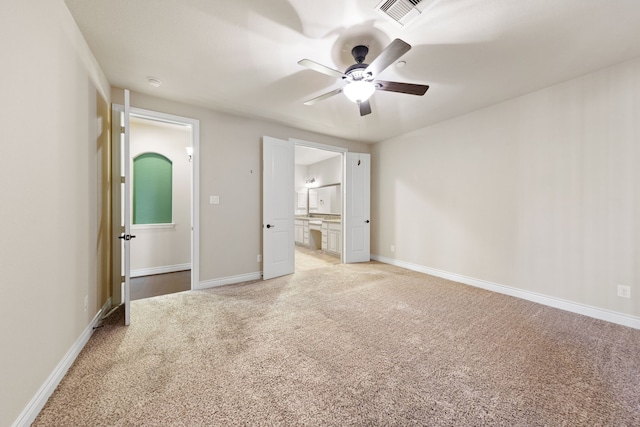 unfurnished bedroom with connected bathroom, ceiling fan, and light colored carpet