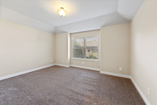 unfurnished room featuring carpet and lofted ceiling