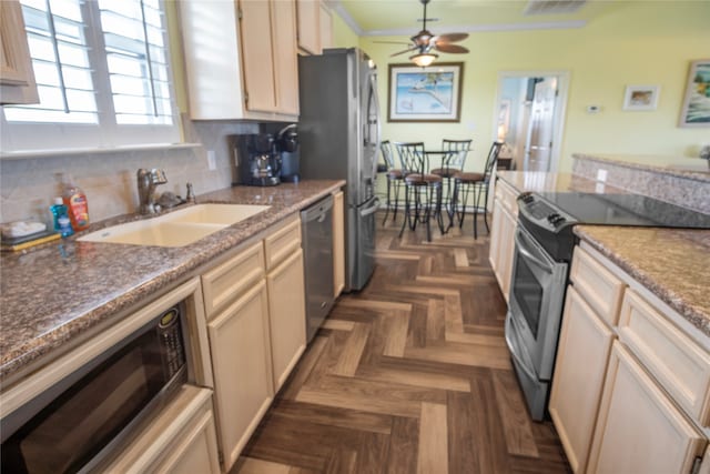 kitchen featuring backsplash, stainless steel appliances, ceiling fan, ornamental molding, and sink