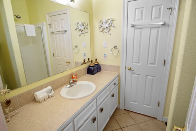 bathroom with walk in shower, vanity, and tile patterned flooring