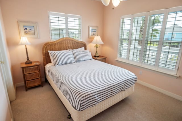 carpeted bedroom featuring multiple windows