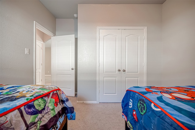 bedroom with a closet and light colored carpet