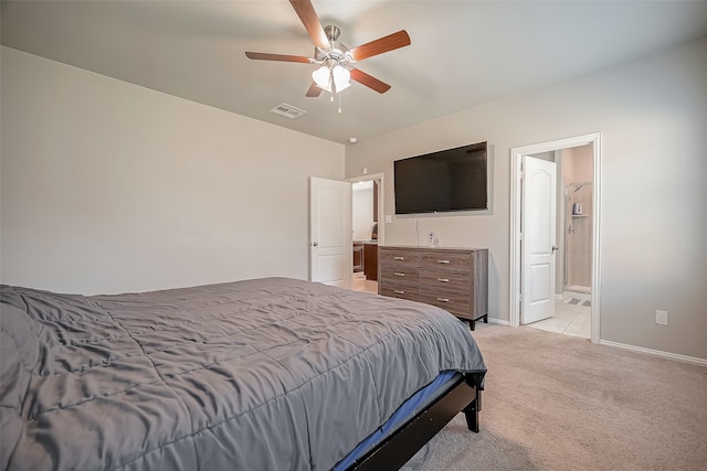 carpeted bedroom with ensuite bath and ceiling fan