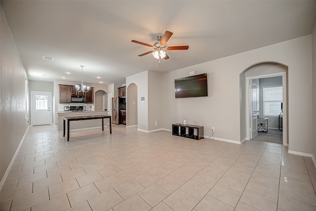 living room with ceiling fan with notable chandelier and light tile patterned floors