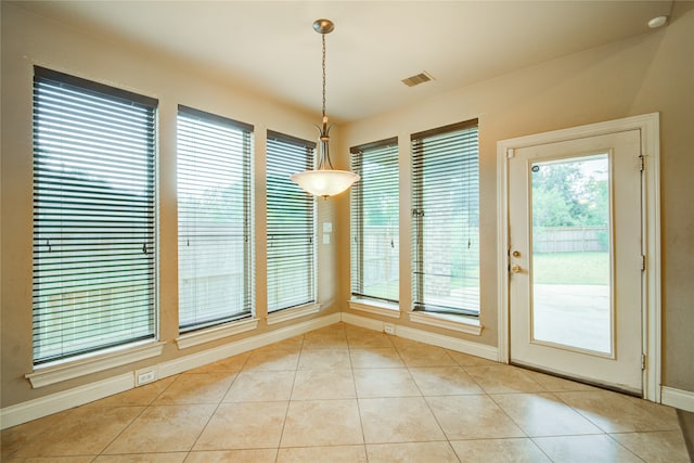 unfurnished dining area featuring a healthy amount of sunlight and light tile patterned floors