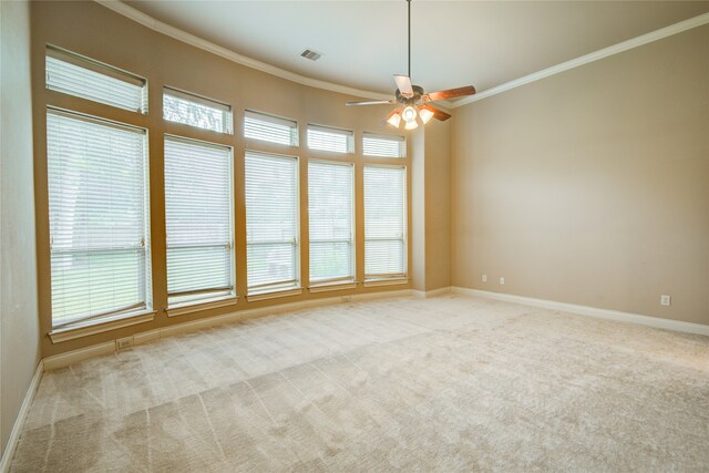 carpeted spare room with ceiling fan and crown molding