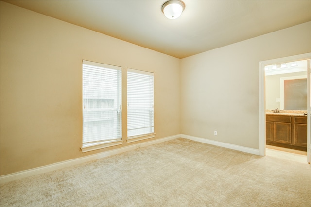 empty room with light colored carpet and sink