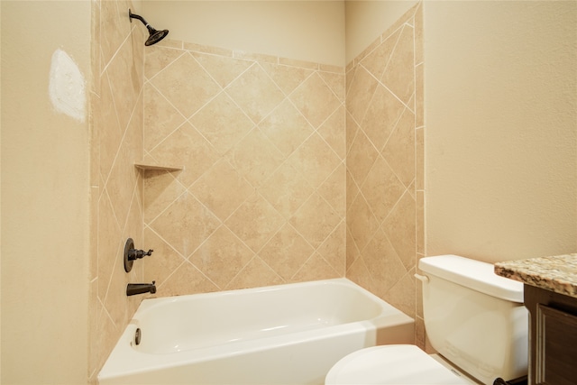 full bathroom featuring tiled shower / bath, vanity, and toilet