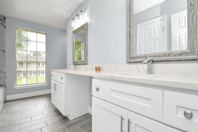 bathroom with a washtub, vanity, and hardwood / wood-style floors