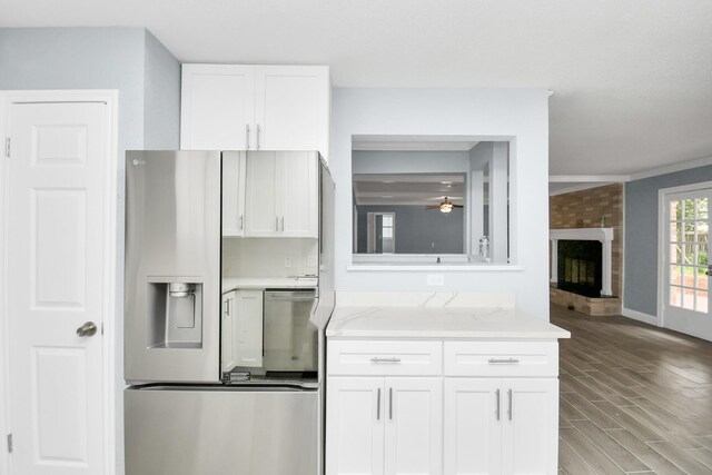 kitchen featuring ceiling fan, light stone counters, a brick fireplace, white cabinetry, and light hardwood / wood-style floors