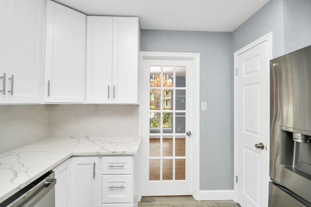 kitchen featuring light hardwood / wood-style floors, white cabinetry, light stone countertops, and stainless steel appliances