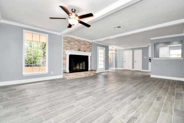 unfurnished living room with ornamental molding, a large fireplace, light hardwood / wood-style floors, and ceiling fan