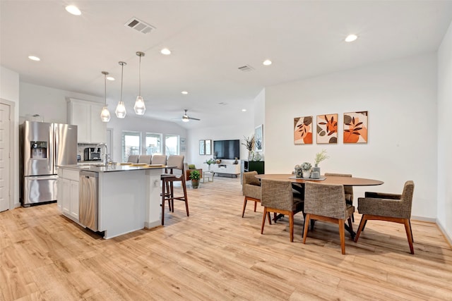 interior space with ceiling fan, light hardwood / wood-style flooring, and sink