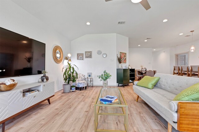 living room with vaulted ceiling, ceiling fan, and light hardwood / wood-style flooring