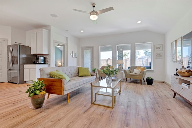 living room with lofted ceiling, light hardwood / wood-style floors, and ceiling fan