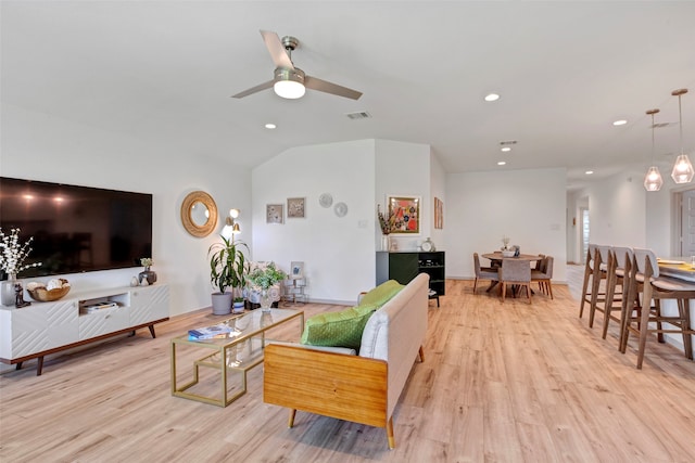 living room featuring light wood-type flooring, vaulted ceiling, and ceiling fan