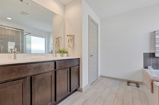 bathroom featuring vanity, separate shower and tub, and hardwood / wood-style flooring